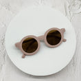 Load image into Gallery viewer, Stylish beige round sunglasses with brown-tinted lenses, elegantly displayed on a white circular platform.
