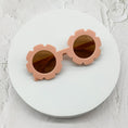 Load image into Gallery viewer, Round sunglasses with peach pink flower-shaped frames and brown lenses, displayed on a white circular surface.
