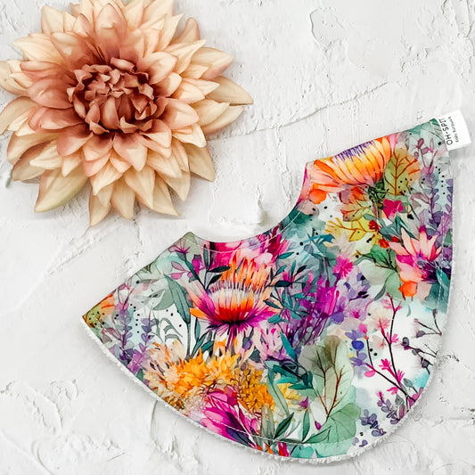 Floral Dribble Bib – Handmade baby bib featuring a vibrant Australian native floral print. Made with a soft cotton front and absorbent towelling backing. Stylish and practical for everyday use.